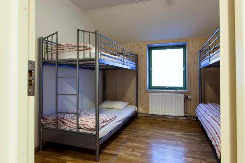 two bunk beds in a room with a window at Russkiy Dom in Longyearbyen