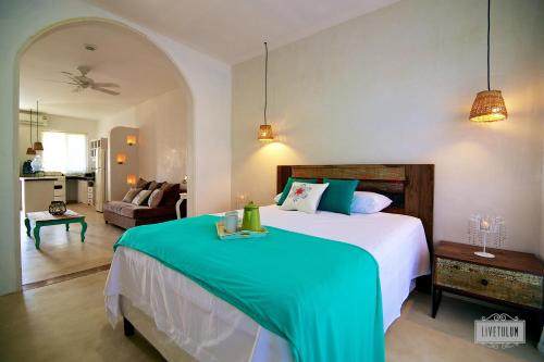 a bedroom with a large bed and a living room at LiveTulum in Tulum