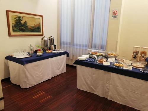 due tavoli in una stanza con sopra del cibo di Hotel Kursaal BB a Salsomaggiore Terme