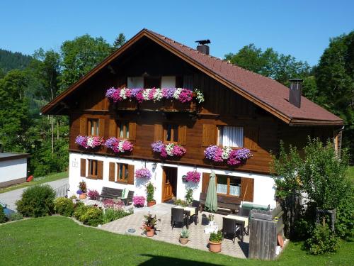 a house with flowers on the side of it at Ferienwohnungen Durst Roswitha in Schattwald