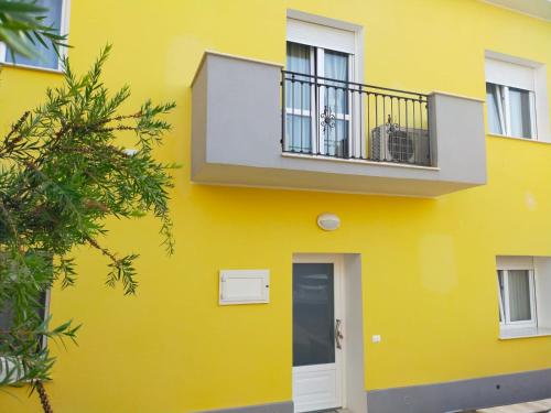 um edifício amarelo com uma varanda e uma porta em Helianthus em Assemini