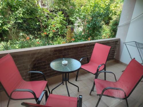 a patio with red chairs and a table on a balcony at Apartments Nebojša in Soko Banja
