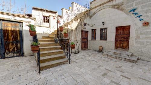 un bâtiment avec un escalier dans une cour dans l'établissement Hikmet's House, à Avanos