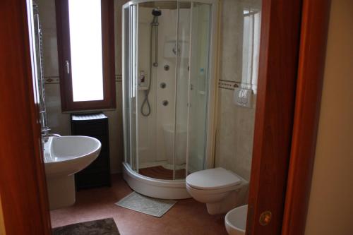 a bathroom with a shower and a toilet and a sink at TETI Rooms in Francavilla Fontana