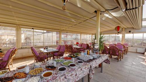 Habitación grande con mesas, sillas y comida. en Hikmet's House, en Avanos