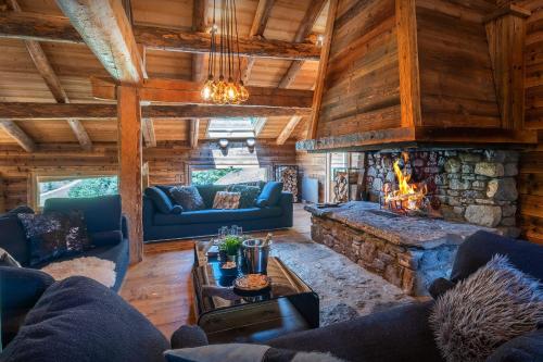 a living room with a fireplace in a log cabin at Chalet Victorina - OVO Network in La Giettaz