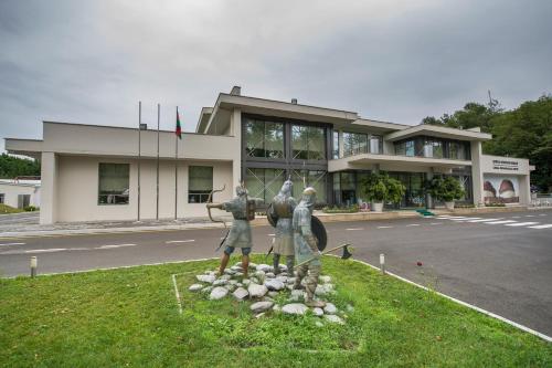 a statue of three people in front of a building at Chukhur Gabala Museum Hotel in Gabala