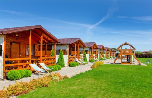 a row of lodges with chairs and a playground at Domki 3W Wicie in Wicie
