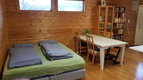 Zimmer mit einem Schreibtisch, einem Tisch, einem Tisch und Stühlen in der Unterkunft One-room cabin without shower in Time