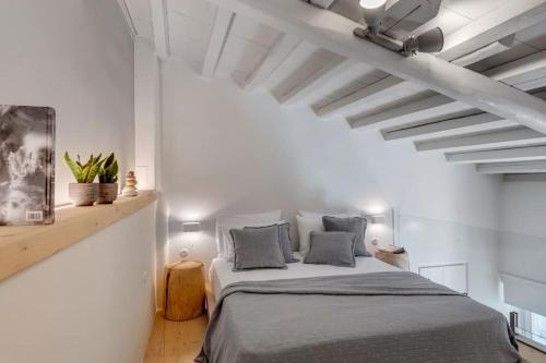 a bedroom with a bed in a white room at Nomade vibrant living loft in Ermoupoli