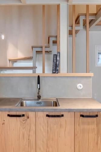 a kitchen with a sink and wooden cabinets at Nomade vibrant living loft in Ermoupoli