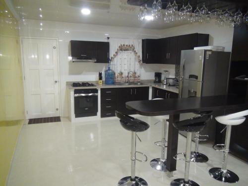 a kitchen with a black counter and a refrigerator at I BBBSAI Casa Vacacional en San Andres Islas – Alquiler in San Andrés