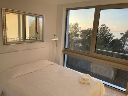 a bedroom with a bed and a large window at PINEA Apartments Pobierowo z niesamowitym widokiem na morze oraz jacuzzi w wybranych apartamentach in Pobierowo