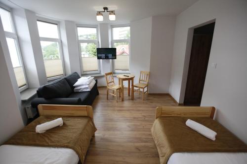 a living room with two beds and a couch at HUZAR in Krynica Zdrój