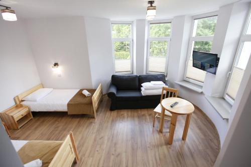 ein kleines Wohnzimmer mit einem Bett und einem Sofa in der Unterkunft HUZAR in Krynica-Zdrój