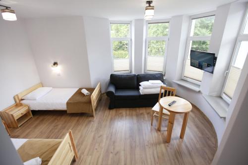 a small living room with a bed and a couch at HUZAR in Krynica Zdrój