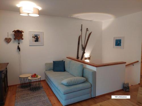 a living room with a blue couch and a table at Appartement Bel Monte in Bad Kleinkirchheim