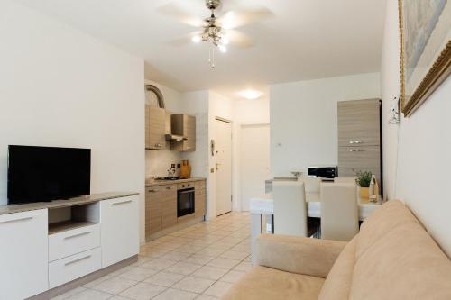 un soggiorno e una cucina con divano e TV di Appartamento Afrodite a Desenzano del Garda