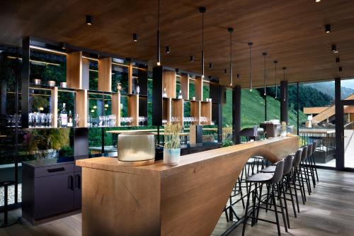 a bar in a restaurant with chairs and tables at ZillergrundRock Luxury Mountain Resort in Mayrhofen