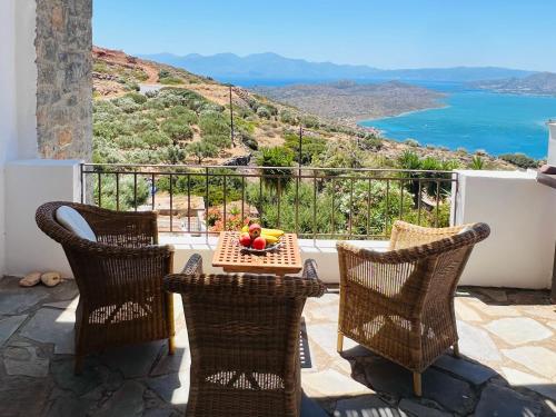 a table and chairs with a view of the ocean at Beautiful Villa Helios with stunning sea view! in Vrouhas
