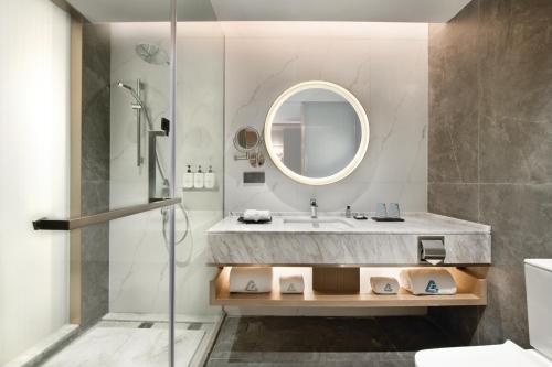 uma casa de banho com um lavatório e um espelho em 深圳花园格兰云天大酒店-免费迷你吧&延迟14点离店 em Shenzhen