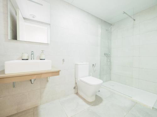 biała łazienka z toaletą i umywalką w obiekcie Cubo's Sea View Pacifico Street & Free Parking w Maladze
