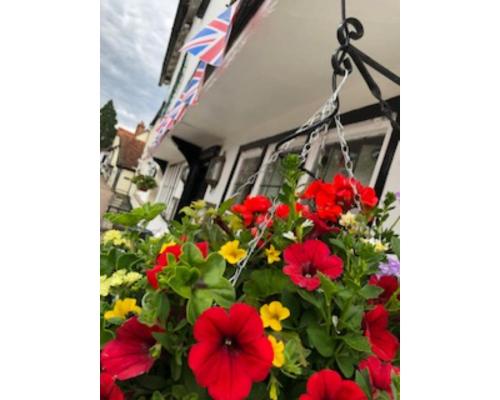 a flower pot with red and yellow flowers and an american flag at The Yew Tree in Manuden