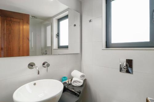 a bathroom with a white sink and a mirror at Alexis Hotel in Chania