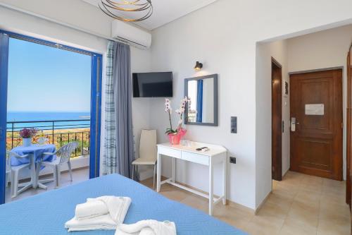 a bedroom with a bed and a view of the ocean at Alexis Hotel in Chania Town