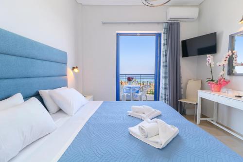 a bedroom with a large bed with towels on it at Alexis Hotel in Chania Town