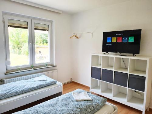 sypialnia z telewizorem i łóżkiem w obiekcie 3 room flat with terrace and garden w mieście Celle