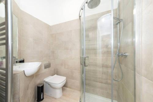 uma casa de banho com um chuveiro, um WC e um lavatório. em Lovely 1-BDR w/ free parking in central Reading em Reading