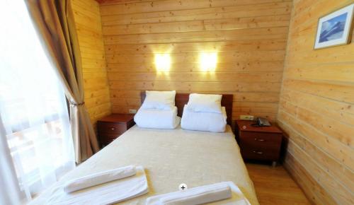 ヤシニャにあるHotel Forward Pool&Saunaの木造キャビン内のベッド1台が備わる小さな客室です。