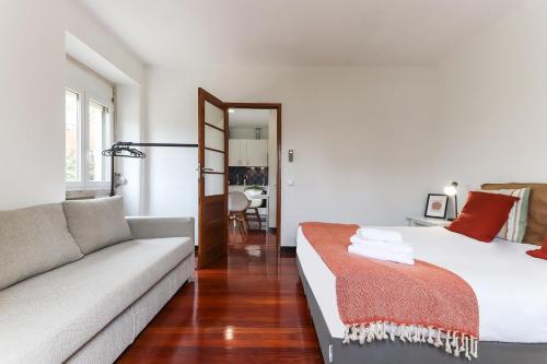 uma sala de estar com uma cama e um sofá em Belem Boutique Apartments by Homing em Lisboa