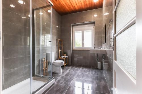 a bathroom with a shower and a toilet and a sink at Nine Horizons Belém in Lisbon