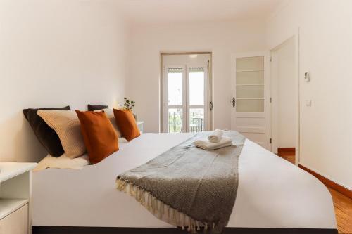 a large white bed with a towel on it at Nine Horizons Belém in Lisbon