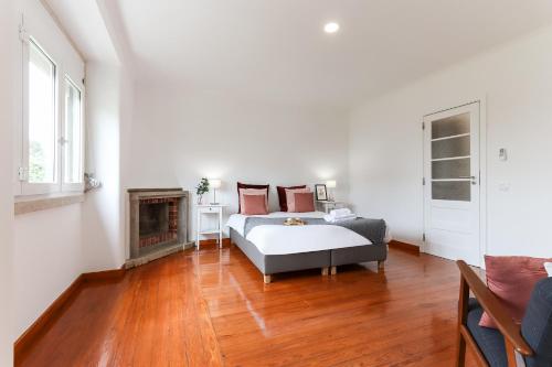 a white bedroom with a bed and a fireplace at Belem Boutique Apartments by Homing in Lisbon