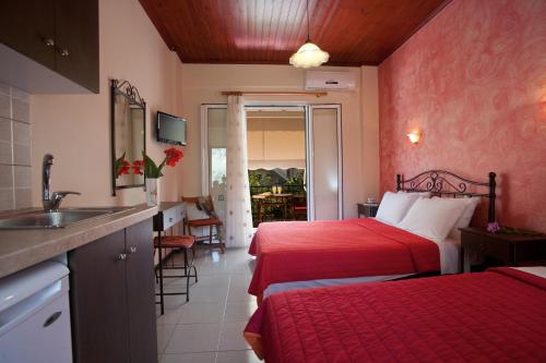 a hotel room with two beds and a sink at Natasa Studios in Mikros Gialos