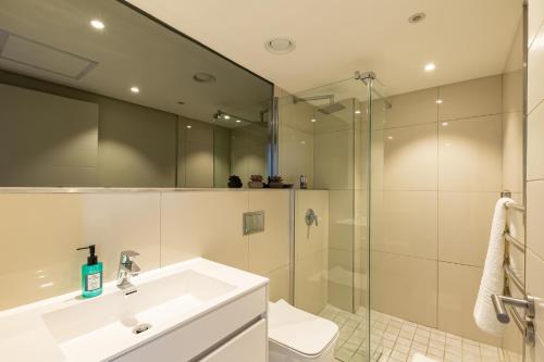 uma casa de banho com um lavatório branco e um chuveiro em Docklands Luxury Two Bedroom Apartments em Cidade do Cabo