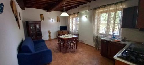 een woonkamer met een blauwe stoel en een tafel bij Agriturismo La Casina in Saturnia