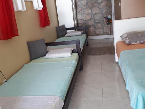 ein Zimmer mit 3 nebeneinander stehenden Betten in der Unterkunft Nice home with private terrace situated near the beach in Tribanj-Krušćica