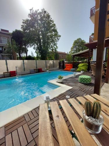 a swimming pool with a bench and cactus at Maison des Roses in Cesenatico