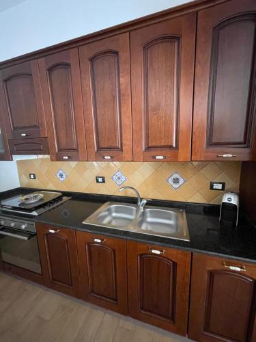 una cucina con armadi in legno e lavandino di Casa vacanze Miceli a Montallegro