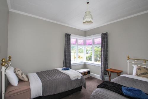 a bedroom with two beds and a window at Tyne and Tides in Oamaru