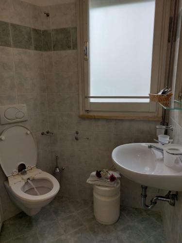 a bathroom with a toilet and a sink at Maison des Roses in Cesenatico