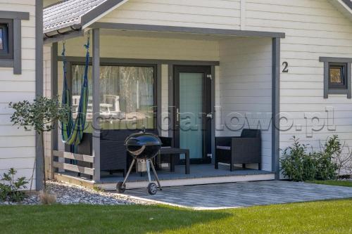 a screened in porch of a house with a grill at Domki letniskowe Alma, Jarosławiec in Jarosławiec