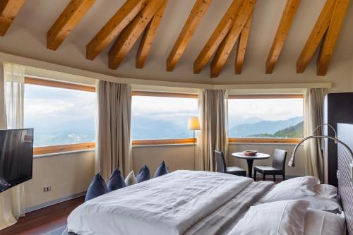 a bedroom with a large bed and large windows at Hotel Norge in Norge