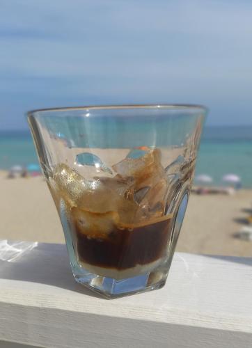 a glass cup with a drink in it on a table at Meerblick-Ferienhaus Casa Gino Apulien in San Pietro in Bevagna