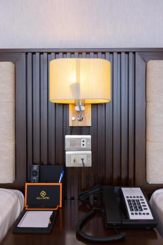 a room with a desk with a laptop and a lamp at SALA HOTEL MÓNG CÁI in Móng Cái