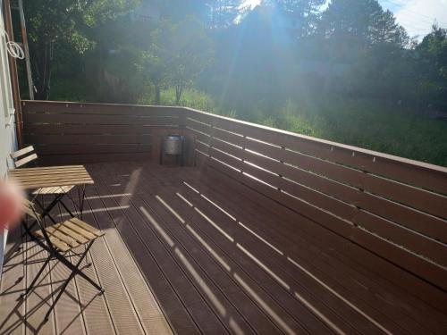 a deck with a wooden fence and a table and chairs at Mountain View Lodge Bulgaria in Ranentsi